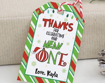 May include: A red and green striped Christmas gift tag with the text "Thanks for celebrating our Mean One. Love, Kayla".