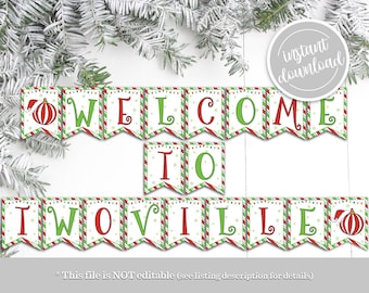 May include: Printable Christmas banner with red and green striped flags. The banner reads "Welcome to Iwoville" with a red and green ornament on each end.