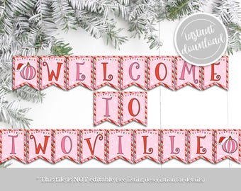 Puede incluir: Una pancarta imprimible rosa y roja con las palabras "Bienvenido a Iwoville" en una fuente festiva. La pancarta está decorada con rayas de bastón de caramelo y copos de nieve.