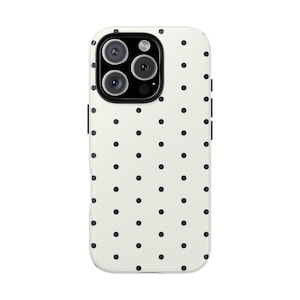 May include: A phone case with a cream-colored background and a pattern of evenly spaced black polka dots. The case has a camera cutout with three lenses and a flash. The case is designed to fit a smartphone.