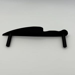 May include: A black knife-shaped object with two vertical supports. The object has a curved blade and a handle-like design. The supports are cylindrical and perpendicular to the blade. The item is likely a display stand.