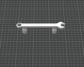 May include: A white wrench with a circular opening on one end and a U-shaped opening on the other. The wrench is elevated by two cylindrical supports, set against a grid background.