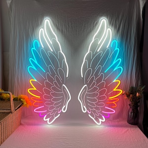 May include: A neon sign in the shape of angel wings. The wings are outlined in white, with sections of blue, yellow, orange, and pink. The sign is designed for wall mounting and adds a decorative touch to any space.