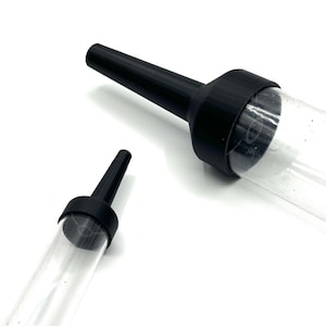 May include: Two clear plastic tubes with black conical nozzles attached to the ends. The nozzles feature a tapered design and a wide circular base that connects to the transparent cylindrical bodies of the tubes.
