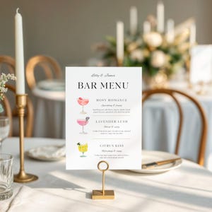 Op de afbeelding: Een witte menukaart met de tekst "Bar Menu" en drankbeschrijvingen, gehouden door een gouden metalen standaard. Het menu bevat aquarel illustraties van cocktails. Een gouden kandelaar en kaarsen staan op de achtergrond.