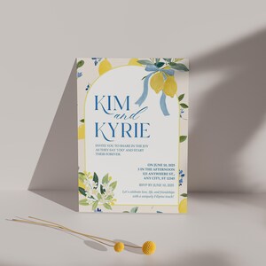 May include: A wedding invitation with a lemon theme. The invitation features the names "Kim and Kyrie" in blue script, with text that reads "Invite you to share in the joy as they say I do and start their forever." The invitation includes the date, time, and location.