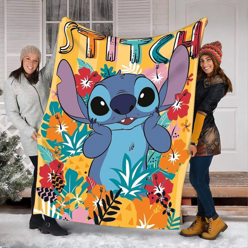May include: A yellow throw blanket featuring the character Stitch from Lilo & Stitch, surrounded by colorful tropical flowers and foliage. The word "STITCH" is written across the top in a playful font. The blanket is held up by two people.