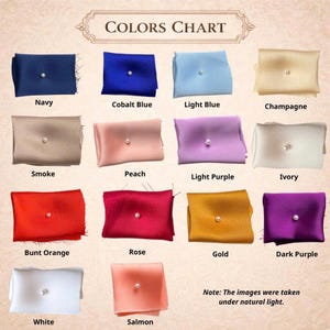 May include: A color chart displaying fourteen rectangular fabric swatches, each featuring a single centered white pearl. The colors include navy, cobalt blue, light blue, champagne, smoke, peach, light purple, ivory, burnt orange, rose, gold, dark purple, white, and salmon.