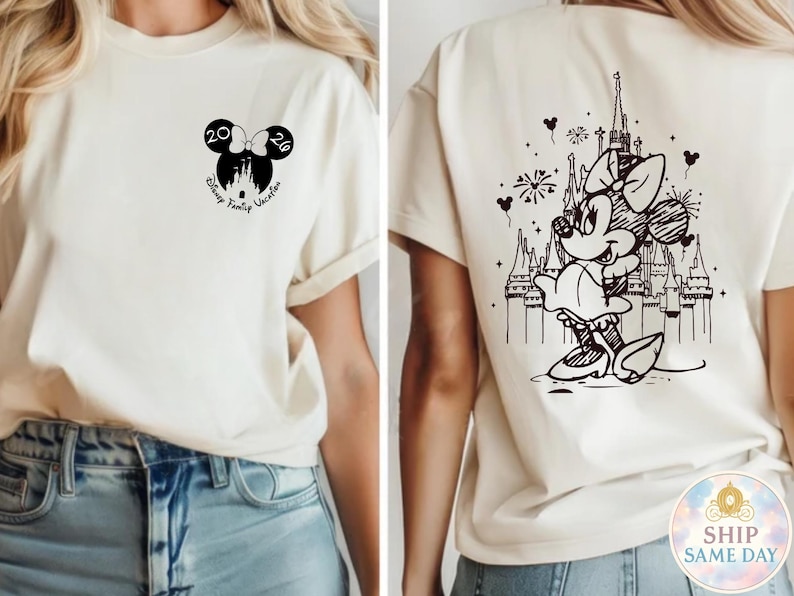 May include: Cream-colored t-shirt with black graphics. The front features a Mickey Mouse ear design with the numbers "20" and "26" and the words "Disney Family Vacation". The back displays a Minnie Mouse illustration in front of a castle.