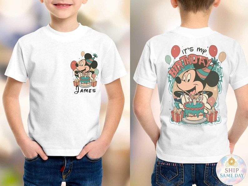 May include: White t-shirt featuring a cartoon Mickey Mouse design with a birthday cake and balloons. The front of the shirt has the name "James". The back of the shirt says "It's my Birthday".