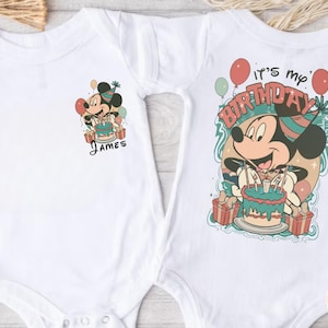May include: White baby bodysuit featuring a colorful Mickey Mouse birthday design. One bodysuit has "James" printed below the graphic. The other bodysuit has "It's my birthday" printed above Mickey Mouse.