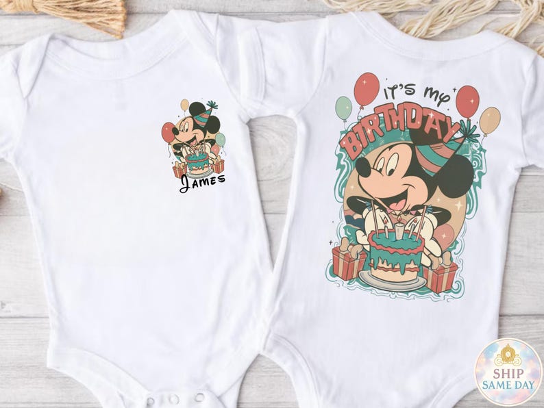 May include: White baby bodysuit featuring a colorful Mickey Mouse birthday design. One bodysuit has "James" printed below the graphic. The other bodysuit has "It's my birthday" printed above Mickey Mouse.