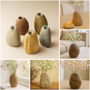 May include: Stone-shaped vases in shades of beige, brown, and grey. Some vases contain white and pastel-coloured flowers. The vases have a natural, organic aesthetic, suitable for home decor. The vases are measured in centimetres.