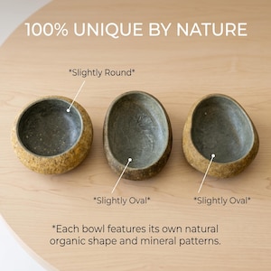 May include: Three stone bowls with unique shapes and mineral patterns. The bowls are in shades of brown and gray, with the text "100% UNIQUE BY NATURE" at the top. The bowls are labeled "Slightly Round" and "Slightly Oval".