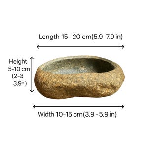 May include: A natural stone bowl with a rough, textured exterior. The oval-shaped bowl measures 15-20 cm in length, 10-15 cm in width, and 5-10 cm in height. The bowl's color is a mix of tan and gray.