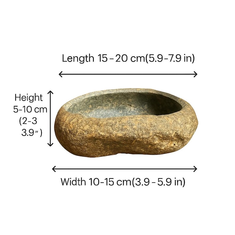 May include: A natural stone bowl with a rough, textured exterior. The oval-shaped bowl measures 15-20 cm in length, 10-15 cm in width, and 5-10 cm in height. The bowl's color is a mix of tan and gray.