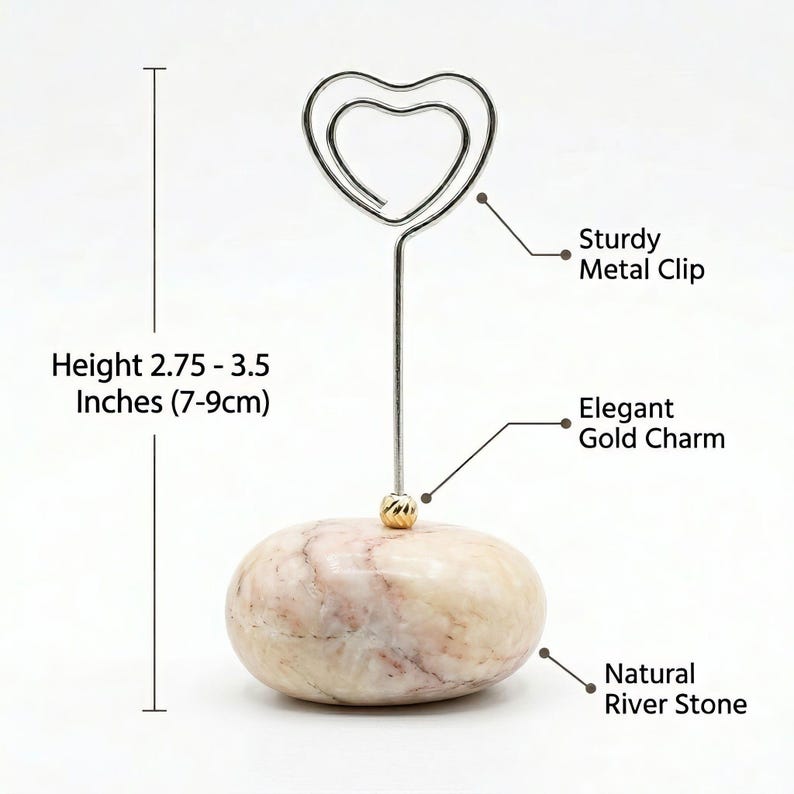 May include: A decorative photo holder with a sturdy metal heart-shaped clip. It features an elegant gold charm and a natural river stone base. The height is 2.75 to 3.5 inches.