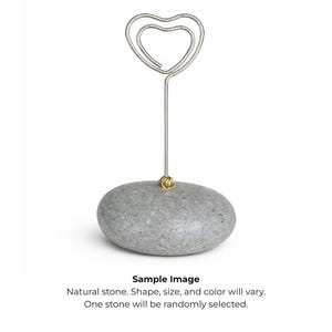 May include: A gray, natural stone base with a silver-colored wire heart-shaped top. The wire is attached to the stone with a small gold-colored accent. The text "Sample Image" and other text are at the bottom.