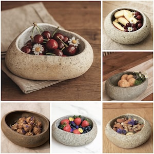 Pode incluir: Uma colagem de tigelas de pedra cheias de vários alimentos. Uma tigela contém cerejas e margaridas, outra maçãs e uvas, e outras contêm nozes, bagas e alimentos fritos. As tigelas estão sobre superfícies de madeira e um pano de linho.