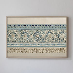 Könnte beinhalten: Ein gerahmtes Kunstwerk mit einem detaillierten floralen und geometrischen Muster in Blau-, Beige- und Cremetönen. Das Design umfasst stilisierte Blumen und aufwendige Bordüren, die eine Vintage-Ästhetik erzeugen. Das Kunstwerk wird an einer weißen Wand ausgestellt.