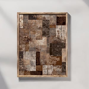 May include: A framed artwork with a patchwork design in shades of brown, beige, and grey. The artwork has a wooden frame and incorporates floral and abstract patterns within the squares. The overall aesthetic is rustic and neutral.
