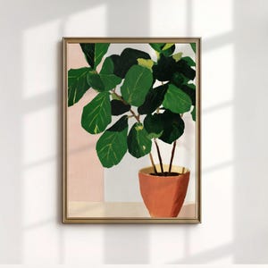May include: A framed art print of a potted plant. The plant has large, green leaves and is in a terracotta-colored pot. The background features a soft pink and white color block design. The frame is gold.
