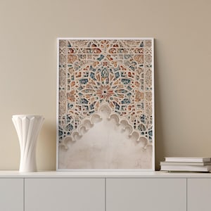 Puede incluir: Impresión enmarcada con un diseño intrincado y decorativo, con un motivo central en forma de estrella. La obra de arte muestra una mezcla de tonos beige, azul y naranja, con un aspecto texturizado y envejecido. La impresión se exhibe sobre una superficie blanca.