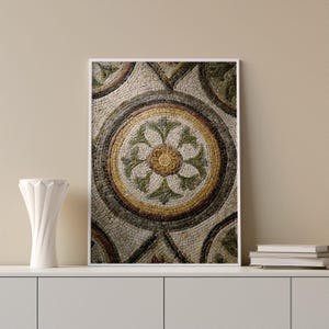 Puede incluir: Impresión enmarcada que presenta un patrón de mosaico detallado. La obra de arte muestra un diseño floral central con un centro amarillo, rodeado de elementos en forma de hojas verdes y blancas. El mosaico está compuesto por pequeñas piedras.
