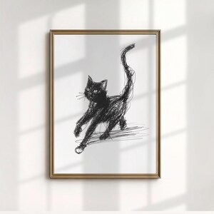 Könnte beinhalten: Ein gerahmter Kunstdruck mit einer Skizze einer schwarzen Katze. Die Katze ist in einer dynamischen Pose mit aufgestelltem Schwanz dargestellt, gezeichnet mit ausdrucksstarken, gekritzelten Linien. Das Kunstwerk befindet sich vor einem weißen Hintergrund, gerahmt in einem goldfarbenen Rahmen.
