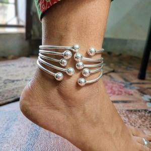 Könnte beinhalten: Ein Set aus drei Keramikbechern mit gesprenkelter, matter Oberfläche. Jeder Becher hat eine andere Farbe: hellblau, cremefarben und grau. Die Becher haben ein schlichtes, modernes Design mit runder Form und Henkel.