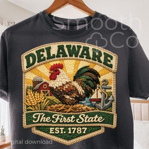 May include: Dark gray t-shirt featuring a detailed embroidered design. The design includes the word "DELAWARE" above a rooster, barn, and anchor. The text "The First State" and "EST. 1787" are also included.