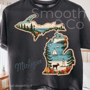 Puede incluir: Camiseta gris oscuro con un diseño bordado del estado de Michigan. El diseño incluye un paisaje con árboles, agua y un faro. La palabra "Michigan" está bordada en la camiseta.
