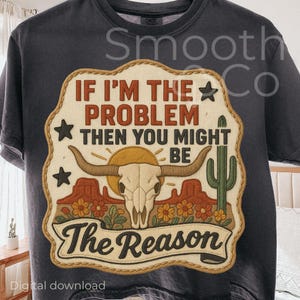 May include: Dark gray t-shirt with a graphic patch featuring a bull skull, desert landscape, and the text "IF I'M THE PROBLEM THEN YOU MIGHT BE THE REASON." The design includes stars, a cactus, and flowers.