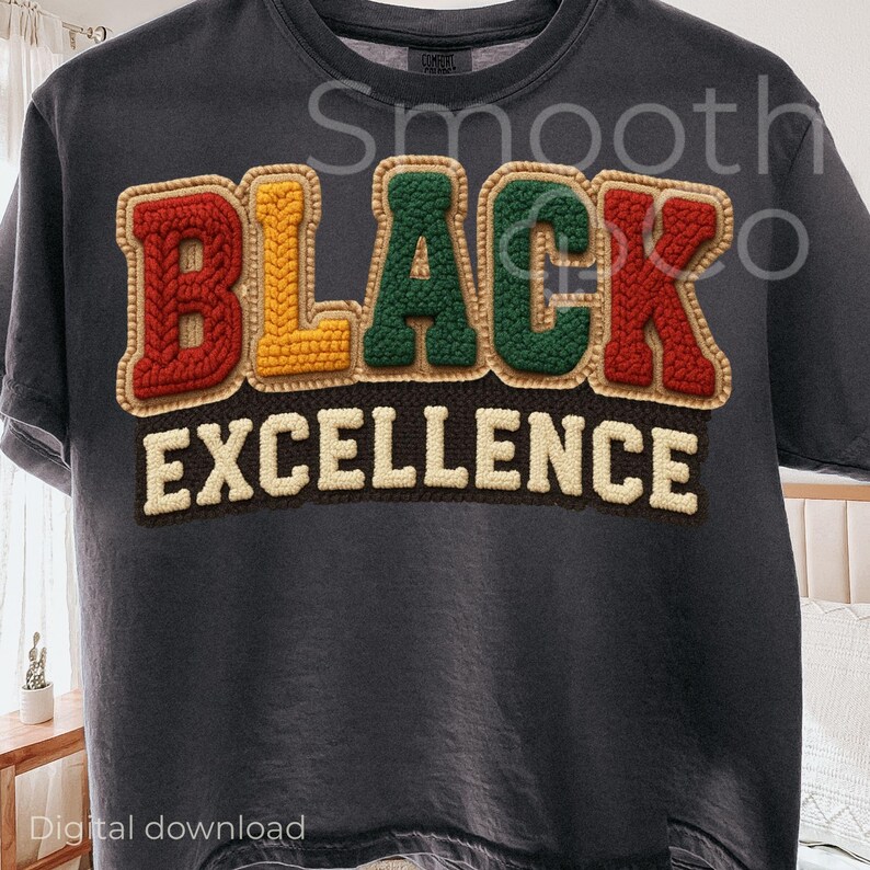 May include: Dark gray t-shirt with the words "BLACK EXCELLENCE" in a colorful, textured design. The letters are in red, yellow, and green, with a brown border. The shirt is a casual wear item.