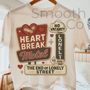 Puede incluir: Camiseta color crema con un gráfico de estilo vintage. El gráfico incluye un letrero rojo que dice "Heart Break Motel" y un letrero que dice "Lonely" con el texto "The End of Lonely Street". La camiseta tiene un cuello redondo clásico.