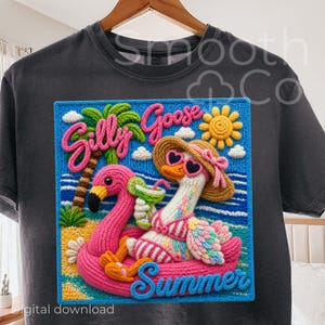 May include: Dark gray t-shirt featuring a colorful, crocheted design. The design includes a pink flamingo and a goose wearing sunglasses and a hat, both floating on a pink floatie. The words "Silly Goose Summer" are displayed.