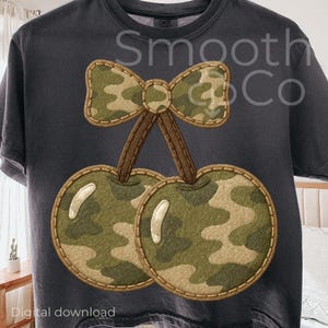 Könnte beinhalten: Dunkelgraues T-Shirt mit einem Camouflage-Kirsch-Design und einer Schleife. Die Kirschen und die Schleife sind in Grün-, Braun- und Beigetönen gehalten und haben einen genähten Rand. Der Text "Smooth Co" ist auf dem Shirt aufgedruckt. Am unteren Rand steht "Digital download".