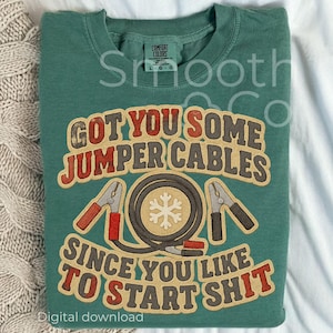 Pode incluir: Camiseta verde Comfort Colors com o texto "GOT YOU SOME JUMPER CABLES SINCE YOU LIKE TO START SHIT". O gráfico inclui um design de cabos de ligação com um floco de neve no meio. Download digital.