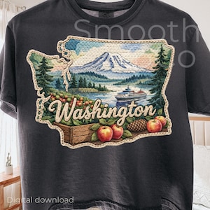 May include: Dark gray t-shirt featuring a detailed embroidered design of the state of Washington. The design includes a mountain, lake, ferry, apples, and the word "Washington".