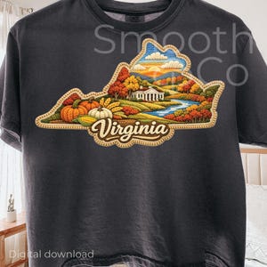 May include: Dark gray t-shirt featuring a detailed embroidered design of the state of Virginia. The design includes pumpkins, corn, a river, and a building, with the word "Virginia" in a decorative font. The shirt has the text "Smooth Co" printed on it.