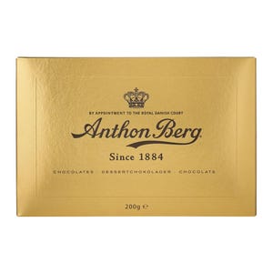 Peut inclure: Boîte dorée de chocolats Anthon Berg. Le nom de la marque, une couronne et l'inscription « Since 1884 » sont visibles. On peut également lire « CHOCOLATES DESSERTCHOKOLADER CHOCOLATS » et « 200g e ».