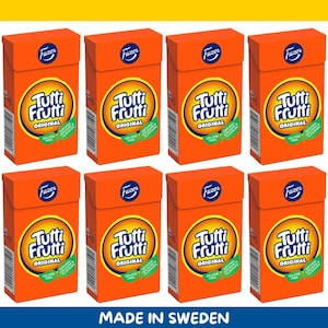 Könnte beinhalten: Acht orangefarbene Schachteln mit Tutti Frutti Original Süßigkeiten. Jede Schachtel hat ein rundes Logo mit dem Markennamen und den Worten "Original", "Gelatinefrei" und "Natürliche Farben & Aromen". Der Text "Made in Sweden" steht unten.