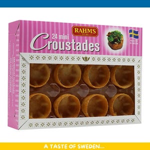 Puede incluir: Una caja de 24 mini "Croustades" con un diseño a rayas rosas y blancas. La caja presenta una ventana que muestra las conchas de pastelería vacías. También se ve el texto "RAHMS" y "PRODUCED IN SWEDEN".