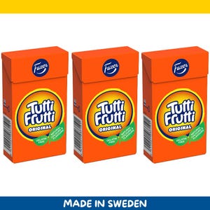 Könnte beinhalten: Drei orangefarbene Schachteln mit Tutti Frutti Original-Bonbons. Jede Schachtel hat ein gelbes und weißes kreisförmiges Logo mit dem Text "Tutti Frutti Original". Die Schachteln tragen auch das Fazer-Logo und die Aufschrift "Gelatinefrei" und "Natürliche Farben & Aromen". Unten steht der Text "Hergestellt in Schweden".