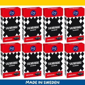 Könnte beinhalten: Acht Schachteln Salmiakki-Bonbons, jede mit rotem Deckel und einem schwarz-weißen Rautenmuster. Die Schachteln zeigen das Fazer-Logo und die Worte "SALMIAKKI SALMIAK ORIGINAL". Der Text "MADE IN SWEDEN" steht unten.