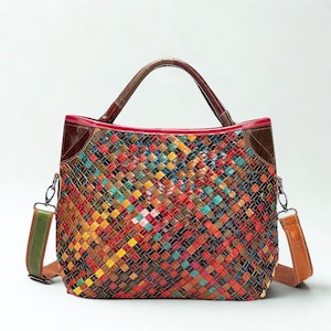 May include: A multi-coloured woven leather handbag with a top handle and a detachable shoulder strap. The bag has a vibrant patchwork design in shades of red, yellow, blue, and green. The top handle and trim are brown.