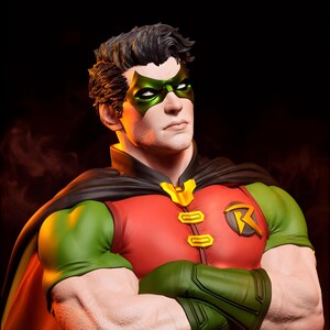 May include: A bust of the DC Comics character Robin. The figure wears a red and green costume with a black cape and a green mask. The figure has a determined expression and crossed arms.
