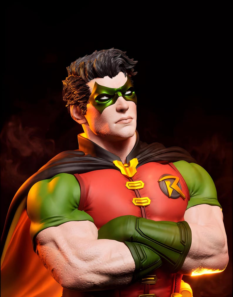 May include: A bust of the DC Comics character Robin. The figure wears a red and green costume with a black cape and a green mask. The figure has a determined expression and crossed arms.