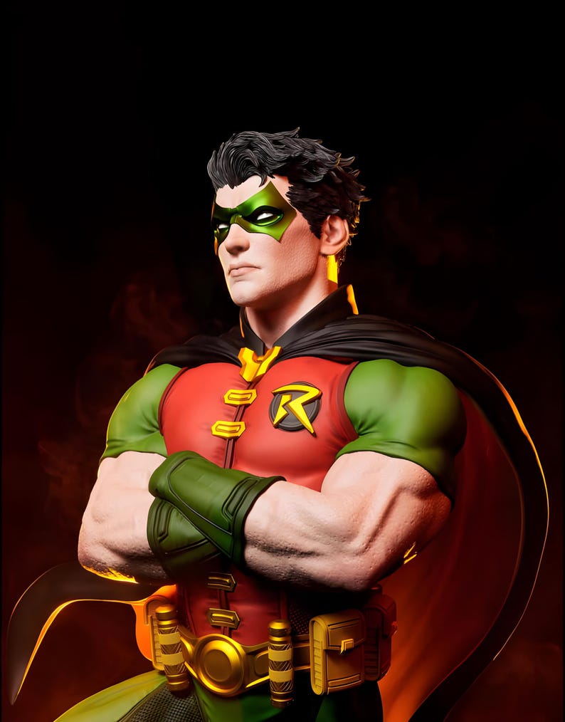 May include: A detailed statue of Robin, a DC Comics superhero, with a red and green costume, black cape, and green mask. The figure has crossed arms and a determined expression, with the iconic "R" emblem on the chest.