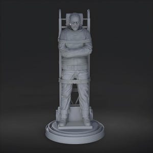May include: A gray sculpture of a person strapped to a restraining chair. The figure is wearing a long-sleeved shirt and pants, with straps across the chest, waist, and legs. The chair has a circular base and a ladder-like back.